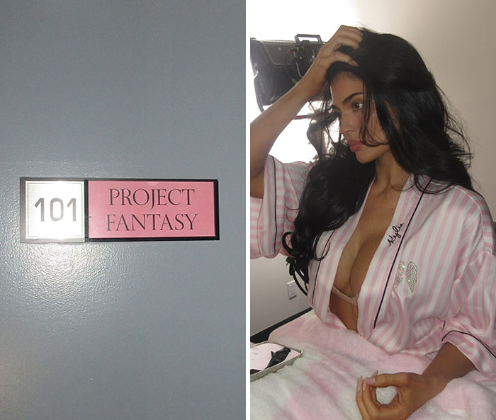 Kylie Jenner backstage in pink robe next to door sign reading Project Fantasy 101 at Victoria's Secret Show