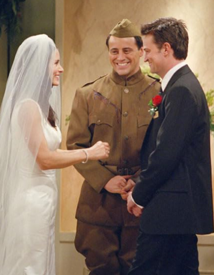 Matthew Perry as Chandler Bing with Monica and Joey in an iconic Friends scene.