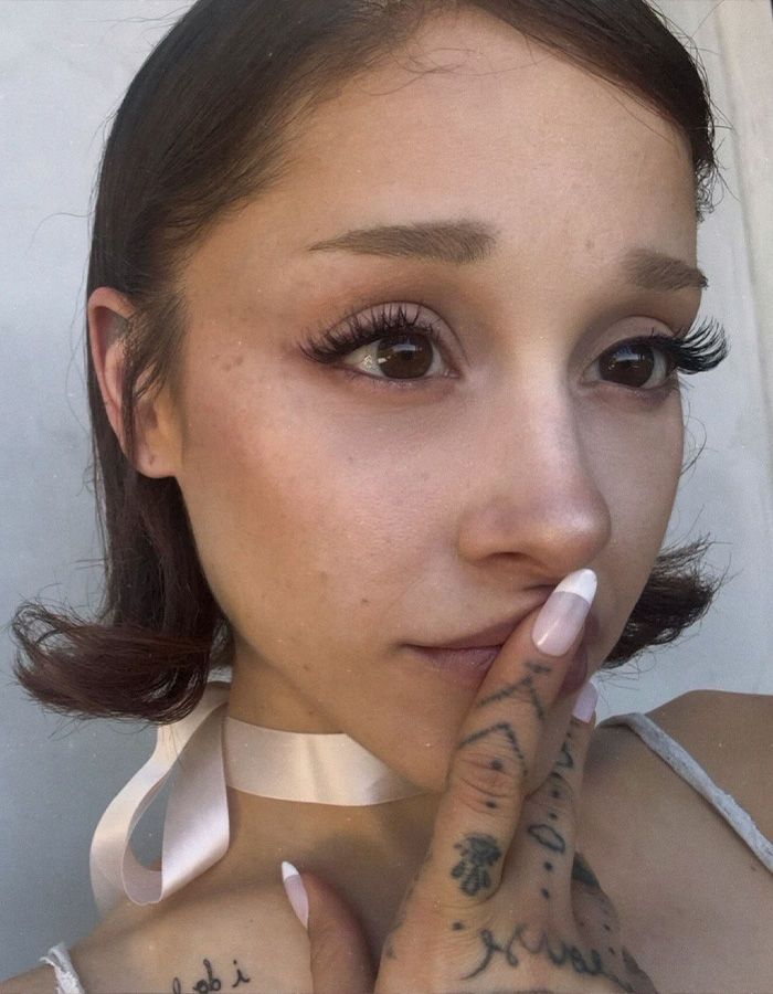 Close-up selfie of Ariana Grande displaying her hair transformation and short dark hairstyle.