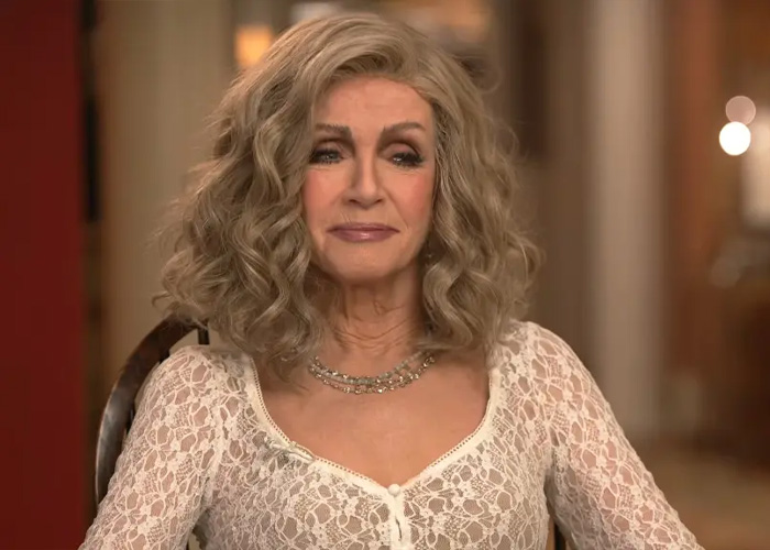 Knots Landing star Donna Mills looking forward with a calm expression while wearing a white lace dress.