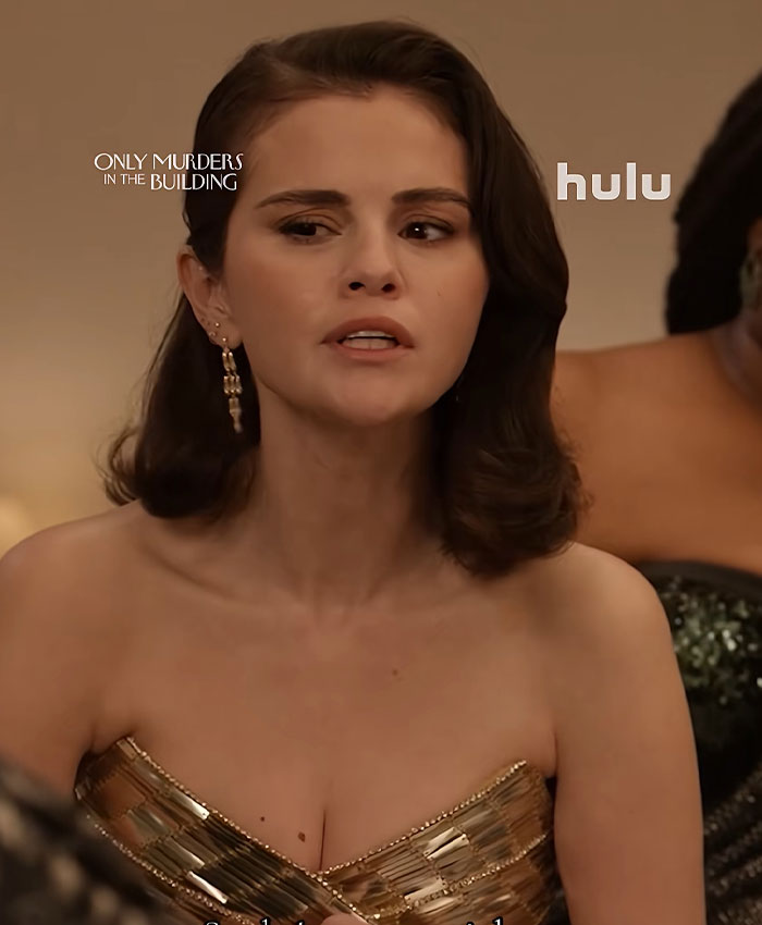 Selena Gomez wearing a strapless metallic gold gown in a scene from Only Murders in the Building.