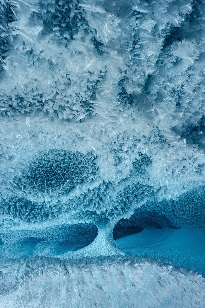 Detailed close-up of icy frost structures in a cool blue natural landscape photograph.