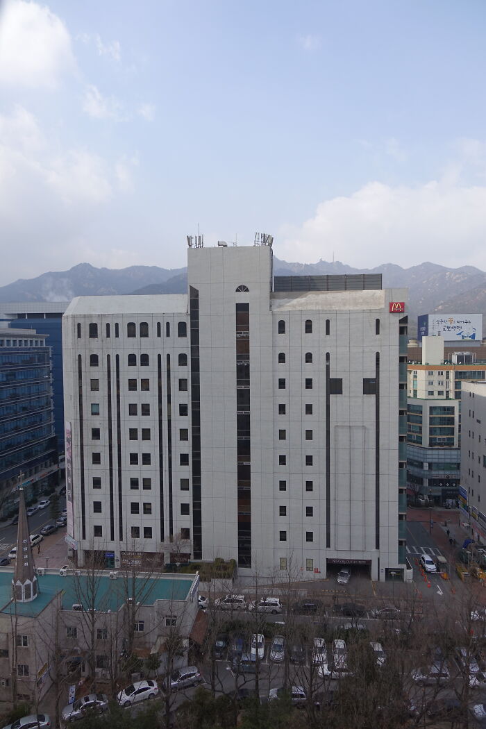 Aerial view of a large white city building associated with active cults.