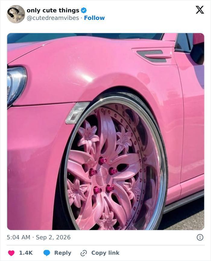Close-up of pink custom car wheel with floral design and matching pink body paint