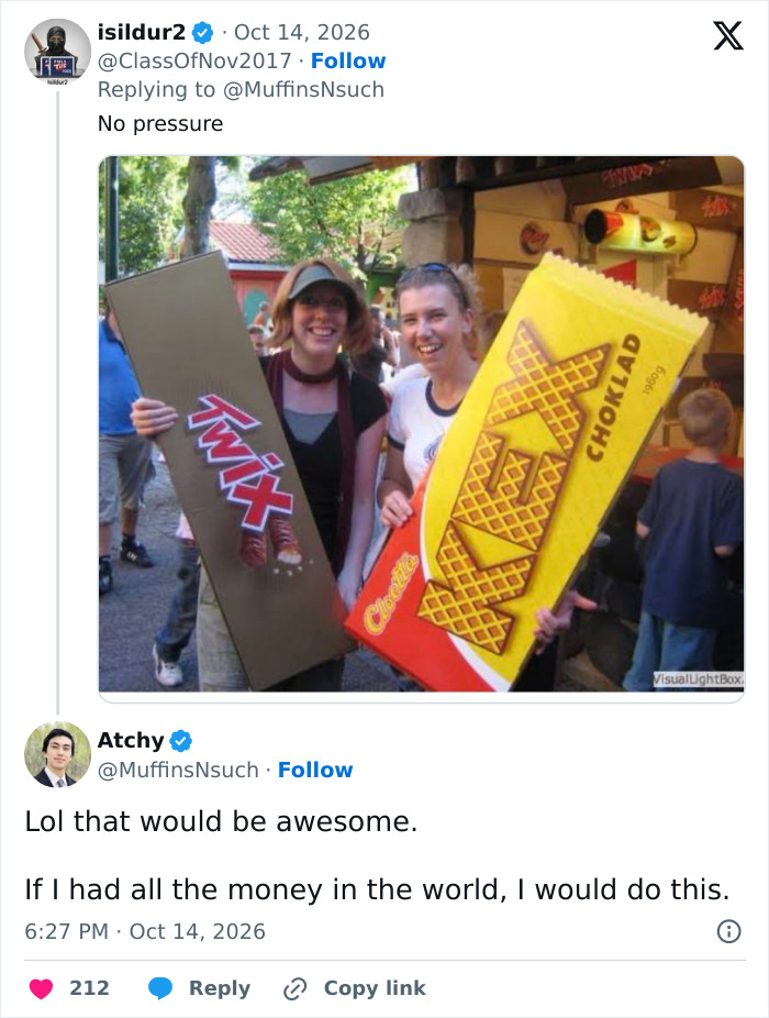 Photo of people holding giant candy bars shared in a social media reply regarding HOA regulations on Halloween candy. Photo of people holding giant candy bars shared in a social media reply regarding HOA regulations on Halloween candy.