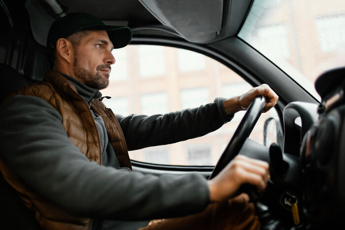 Man driving a vehicle attentively, moving forward through challenging divorce stories.