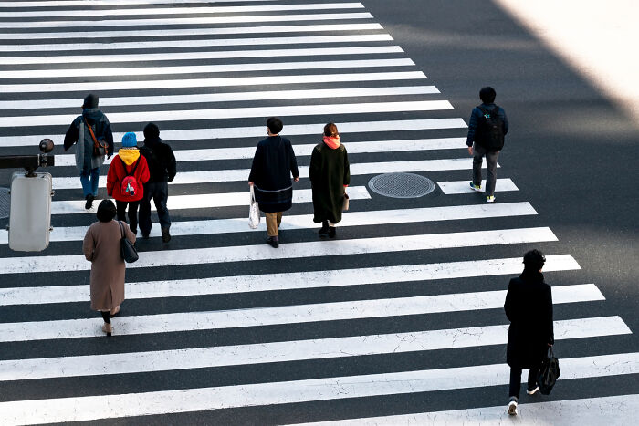 Pedestrians using a zebra crosswalk, following safety guidelines and emergency tips.