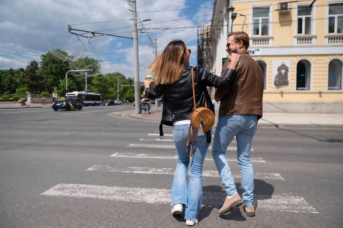 Couple crossing street near traffic, a moment of potential danger in scary survival stories