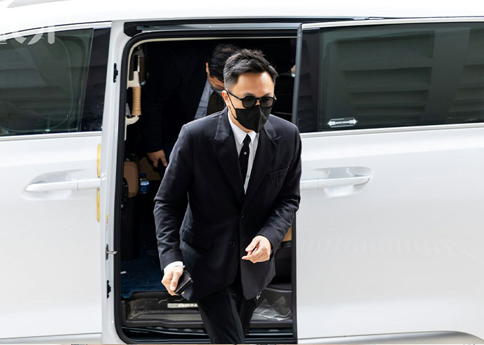 Man in black suit and mask exiting a white vehicle Man in black suit and mask exiting a white vehicle