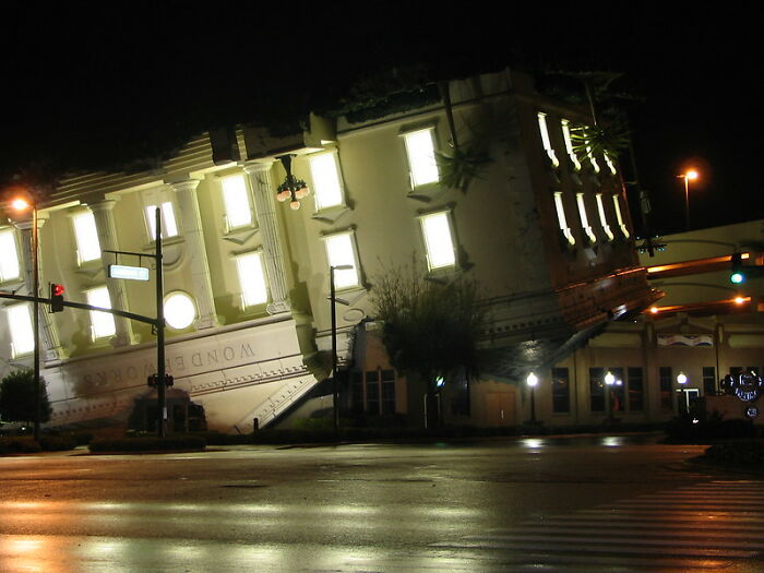 Night view of tilted strange building lighting up the street corner