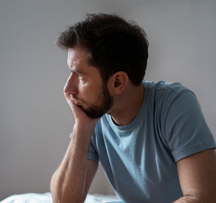 A sad man rests his head on his hand, dealing with his wife’s pregnancy and a secret affair. A sad man rests his head on his hand, dealing with his wife’s pregnancy and a secret affair.