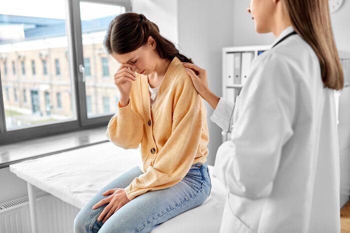 Female doctor comforting upset woman in medical office