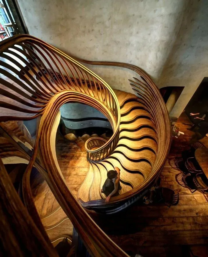 A stunning, hand-carved spiral staircase made of curved timber, highlighting clever wooden creations in design