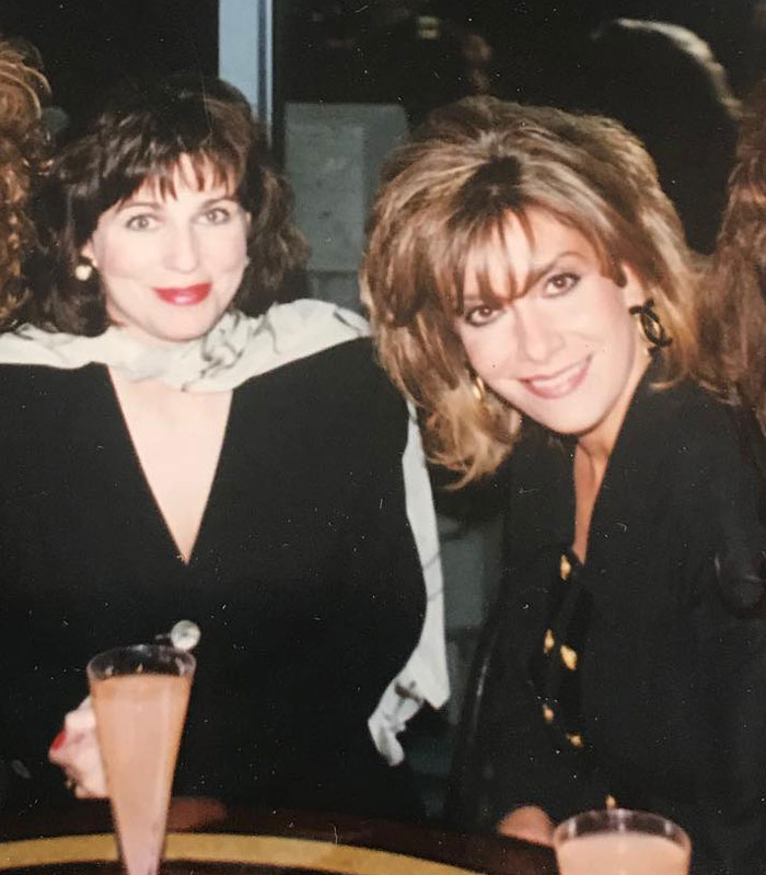 Two elegant women chat at an upscale social event, reflecting the world of the mega-rich.