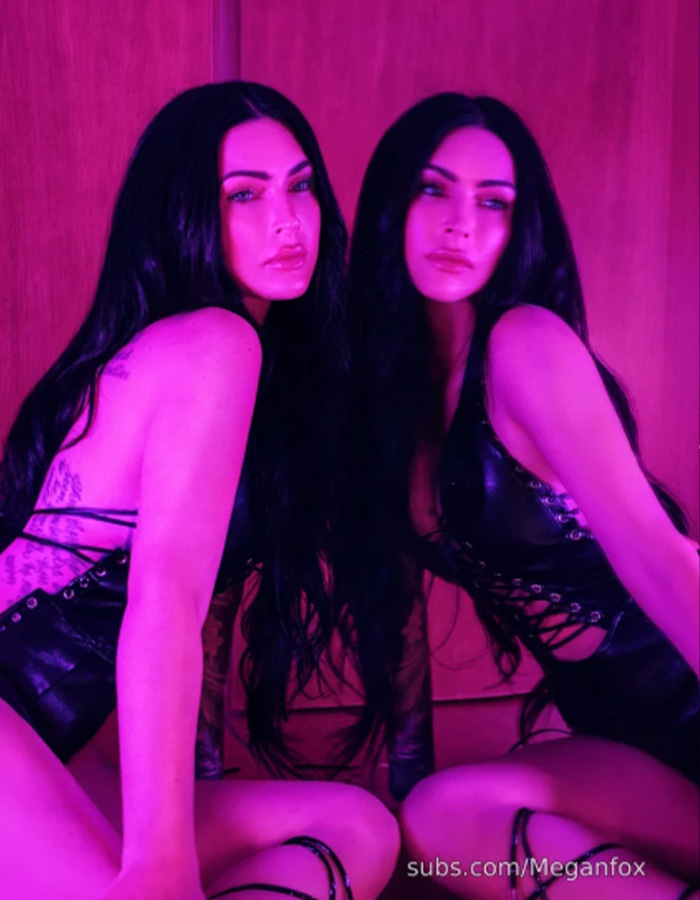 Megan Fox in a dark lace-up outfit under pink lighting, promoting new images for her paid-content site.