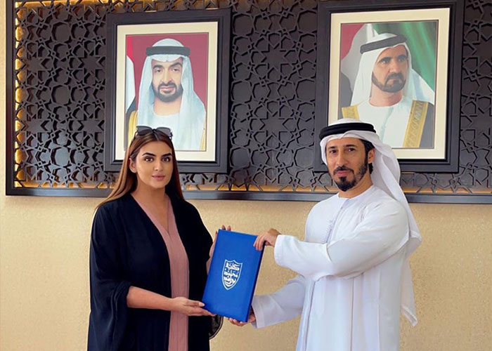 Royal mother receiving an award in front of royal portraits