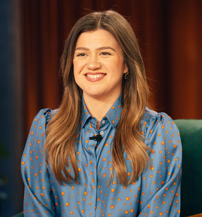 Kelly Clarkson smiling during interview showing confident body language