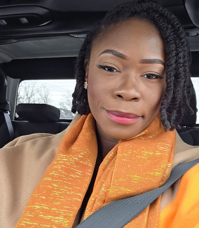 Woman with braided hair wearing an orange scarf inside a car Woman with braided hair wearing an orange scarf inside a car