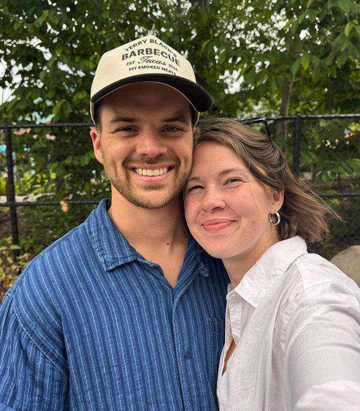 A smiling man wearing a barbecue cap standing next to a smiling woman.