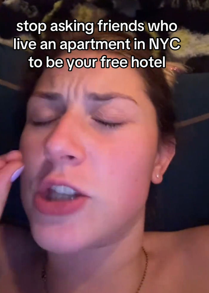 Woman expressing frustration online about visitors avoiding expensive NYC hotels by staying on her couch. Woman expressing frustration online about visitors avoiding expensive NYC hotels by staying on her couch.
