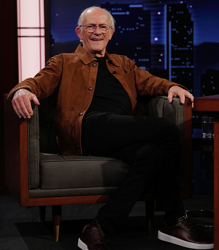 Christopher Lloyd smiling while sitting in an armchair during a talk show. Christopher Lloyd smiling while sitting in an armchair during a talk show.