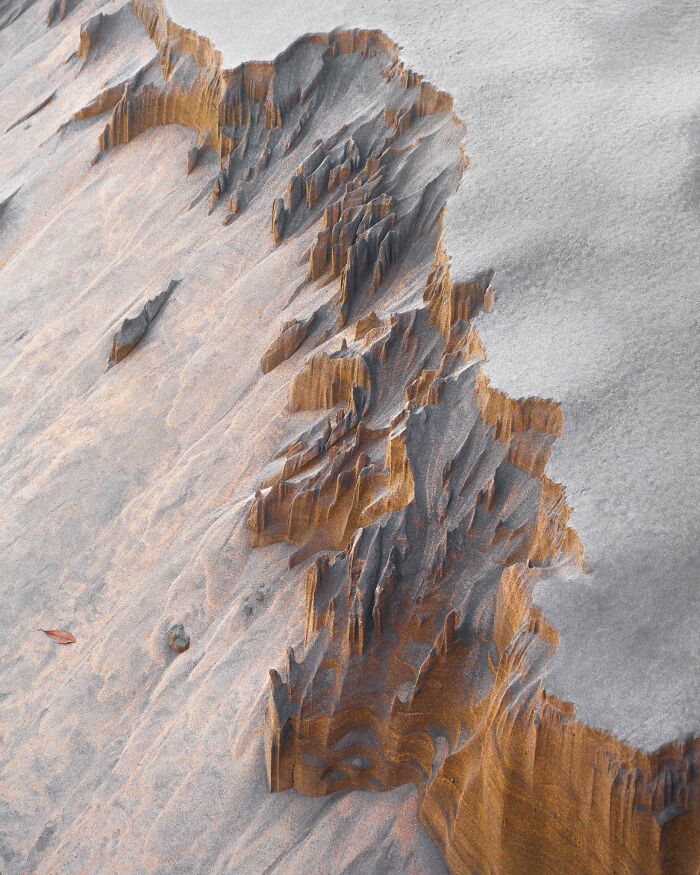 Eroded sand formations along a beach line shown in natural landscape photography.
