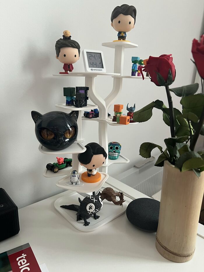 A white modern shelf filled with colorful figures and creative 3D prints.