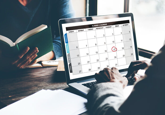 Person using laptop calendar with date circled for planning to get back at an ex