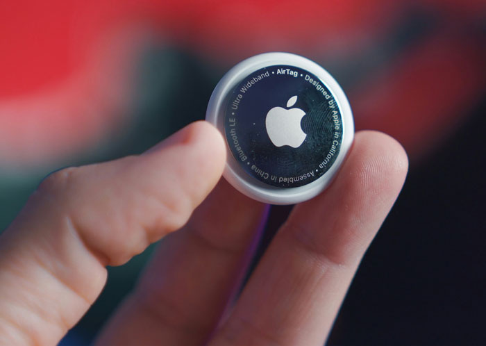 Hand holding an Apple AirTag tracking device related to uncovering a secret affair Hand holding an Apple AirTag tracking device related to uncovering a secret affair