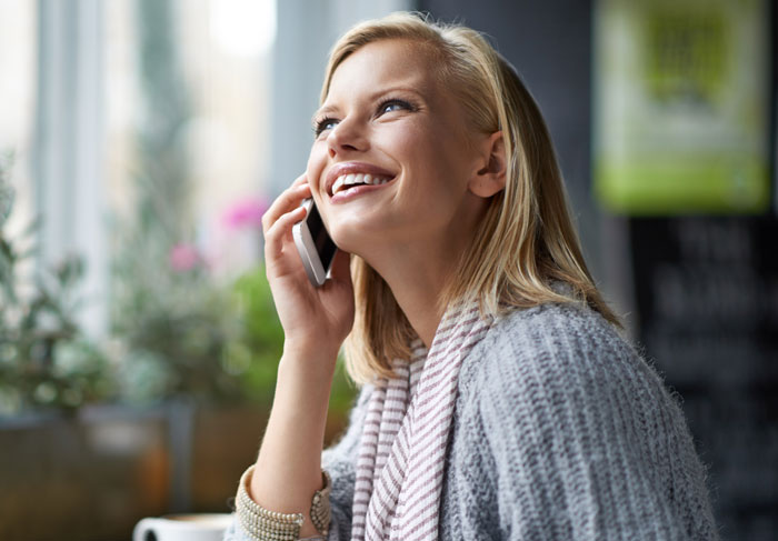 A smiling woman talking on the phone, hiding a secret affair from her husband. A smiling woman talking on the phone, hiding a secret affair from her husband.