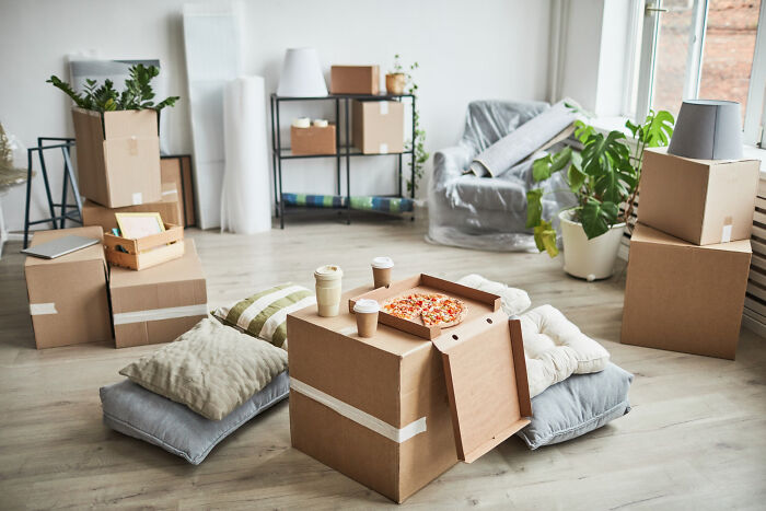 A room packed with moving boxes and pizza during real-life divorce stories packing