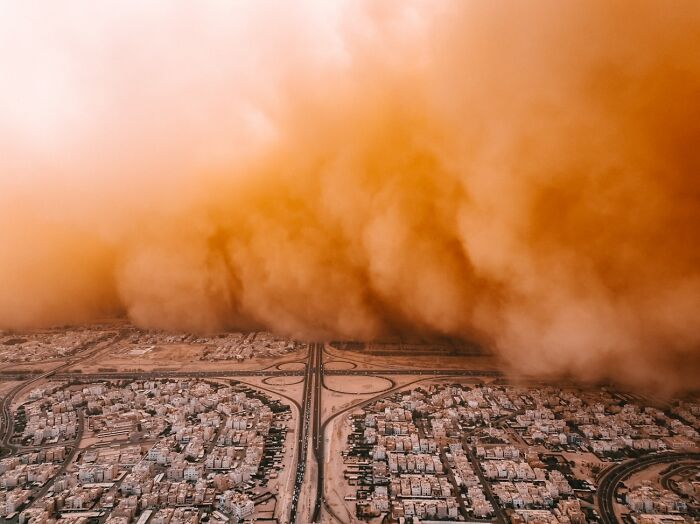 Massive dust storm approaching a city from above, captured for the Siena Drone Photo Awards.
