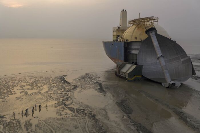 Massive decommissioned ship resting on a muddy shore from the 2026 Siena Drone Photo Awards collection.