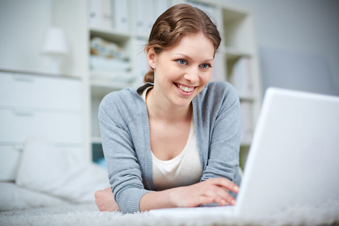 Woman smiling using laptop computer indoors