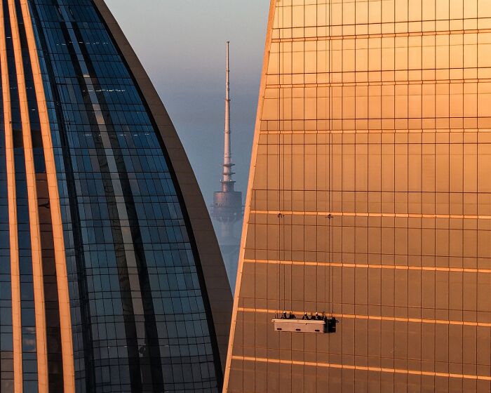 High-rise window washers suspended between skyscrapers, a entry in the 2026 Siena Drone Photo Awards.