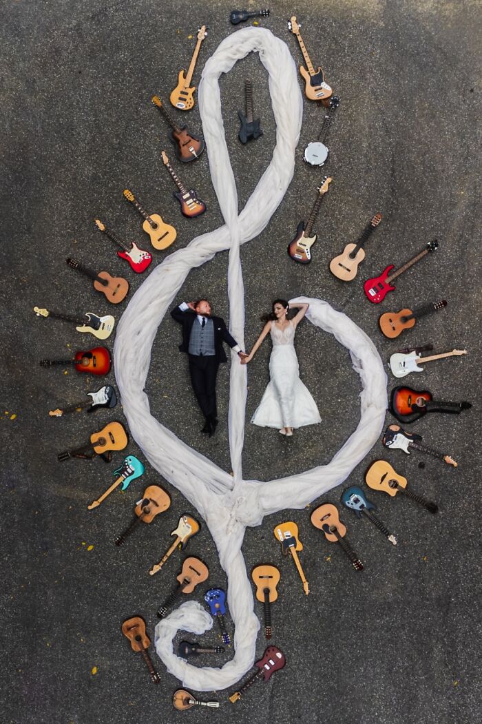 Overhead shot of a couple surrounded by guitars forming a treble clef, featured in the Siena Drone Photo Awards.