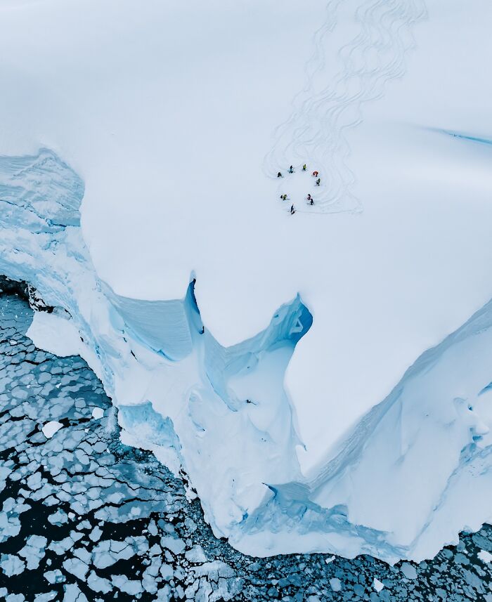 Aerial view of skiers on a snowy mountain top, an entry in the Siena Drone Photo Awards.