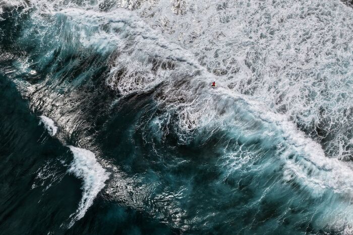 Aerial perspective of ocean waves crashing over a coral reef from the Siena Drone Photo Awards