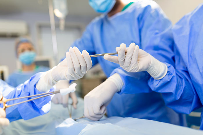 Medical team performing heart surgery in an operating room with surgical tools.