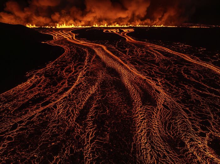 Lava flows glowing brightly at night with fire line horizon volcanic photo