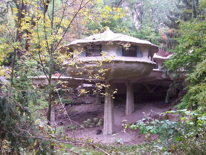 Weird concrete weird building on pillars in dense forest