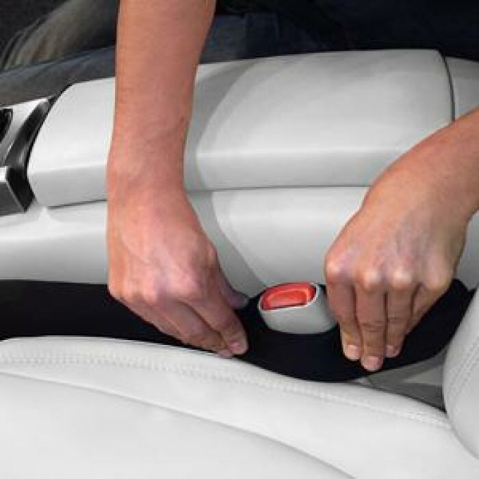 Hands installing a black car seat gap filler during Big Deal Days
