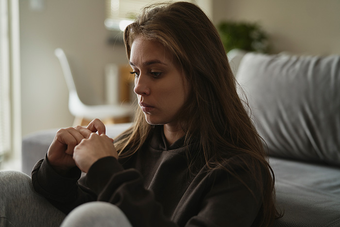 Sad woman sitting thoughtfully as she processes lies before her ex's funeral. Sad woman sitting thoughtfully as she processes lies before her ex's funeral.