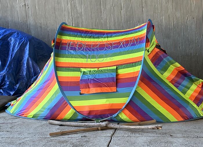 A rainbow tent with the word Heterosexual written across the front in a funny absurd moment.