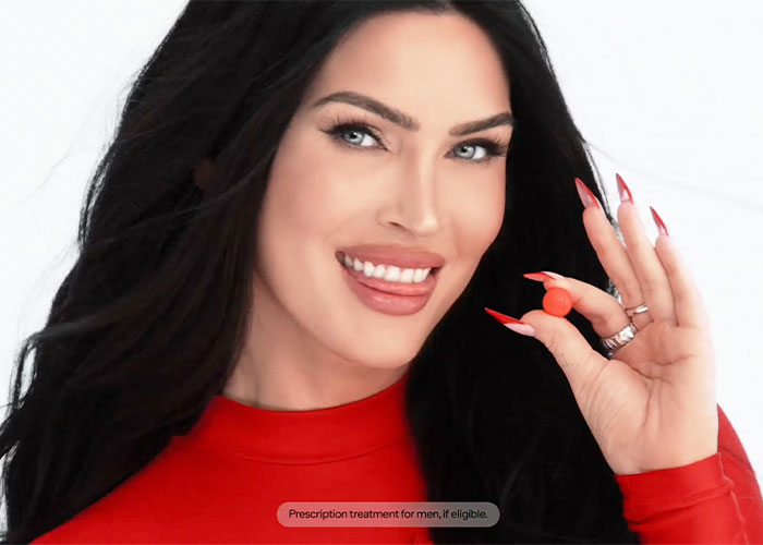 Megan Fox smiling in a red outfit holding a pill from her campaign for male performance issues. Megan Fox smiling in a red outfit holding a pill from her campaign for male performance issues.