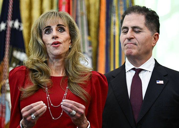 Dell CEO Michael Dell looks on as his wife Susan Dell speaks during an event.