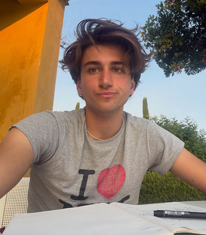 Hollywood star accused of cheating, young man with brown hair sitting outdoors with notebook