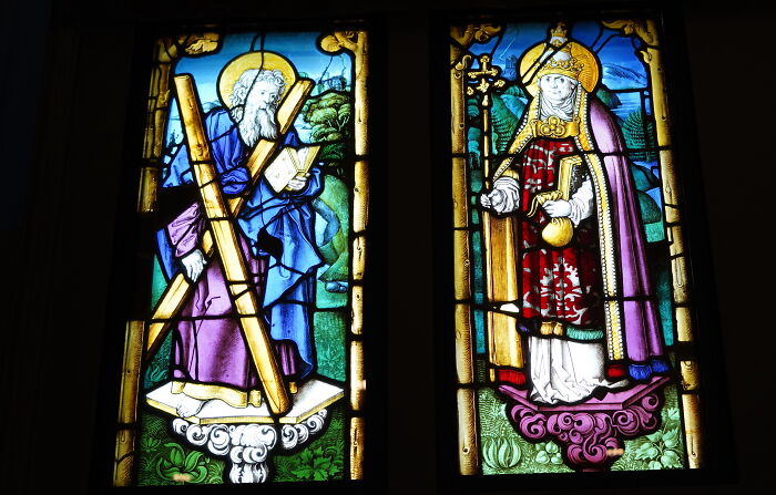 Close-up of two illuminated religious stained-glass windows Close-up of two illuminated religious stained-glass windows