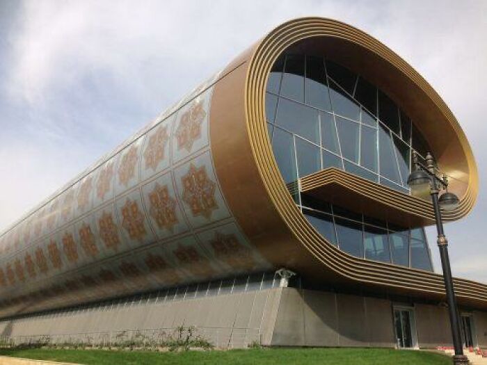 Modern building with a golden curved exterior and patterned decorative designs