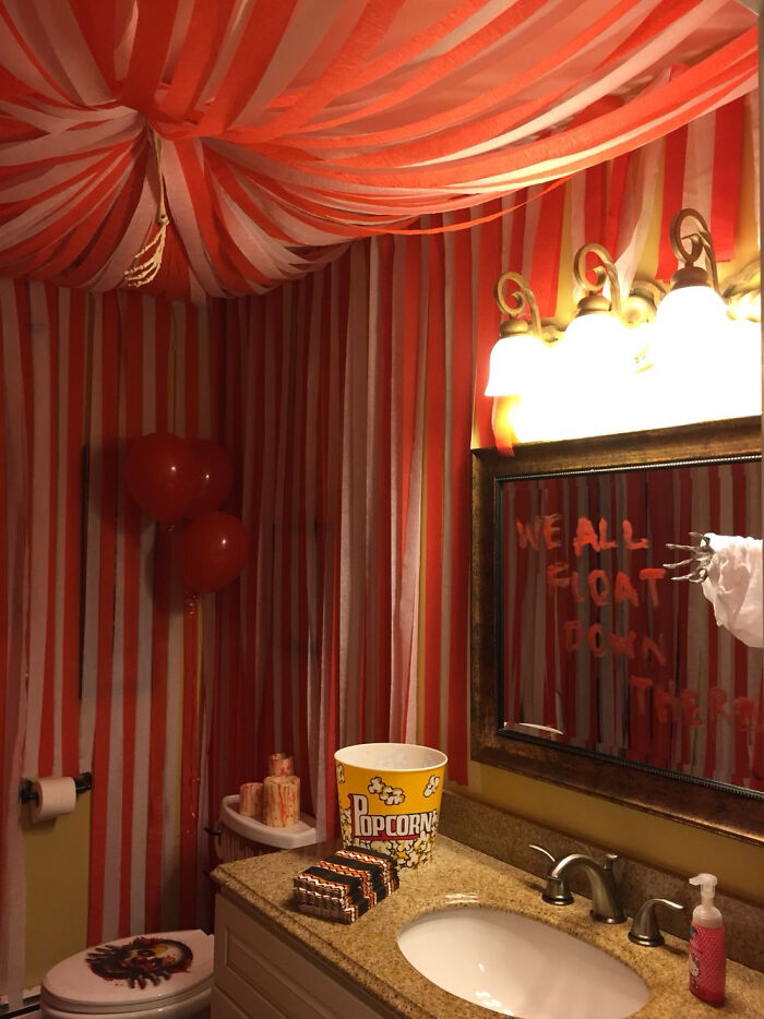 Carnival-themed Halloween home decorations in a bathroom with red and white streamers.